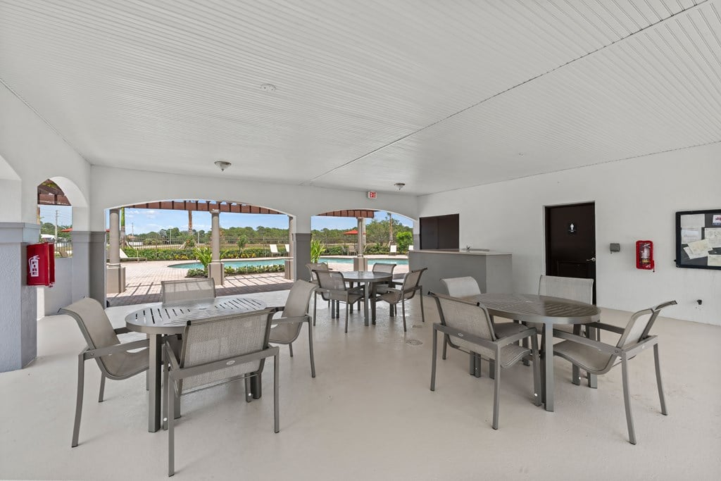 a large living room with tables and chairs and a patio