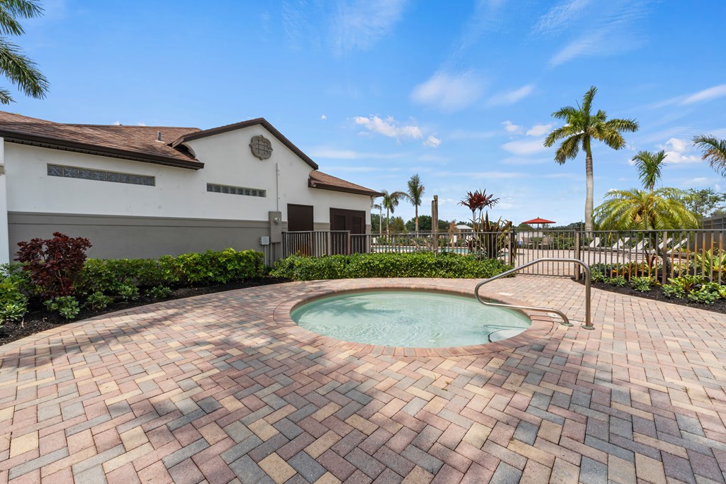a swimming pool with a house and palm trees in the background
