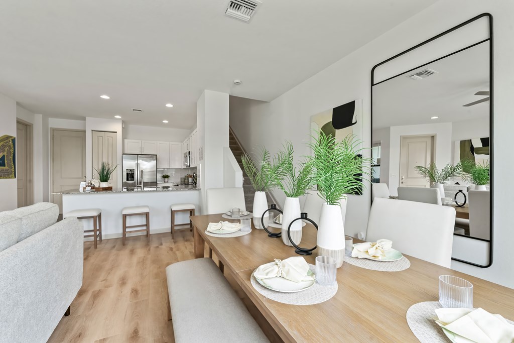 a living room and dining room with a table and chairs