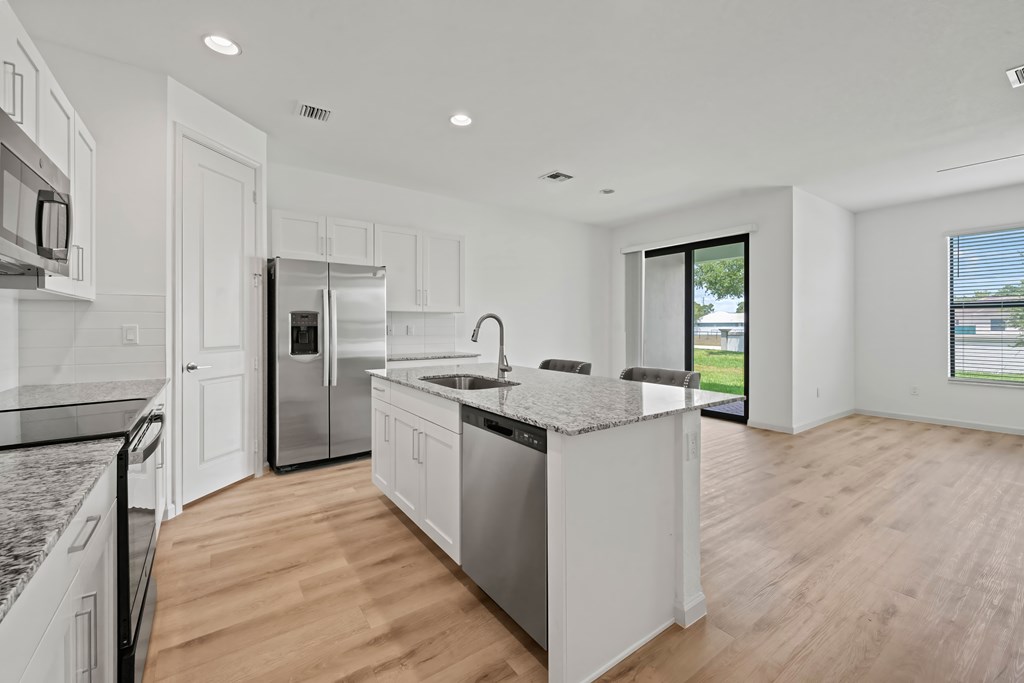 a large kitchen with an island and stainless steel appliances