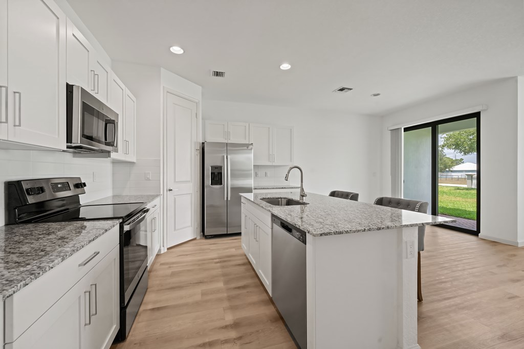 an open kitchen with marble counter tops and stainless steel appliances