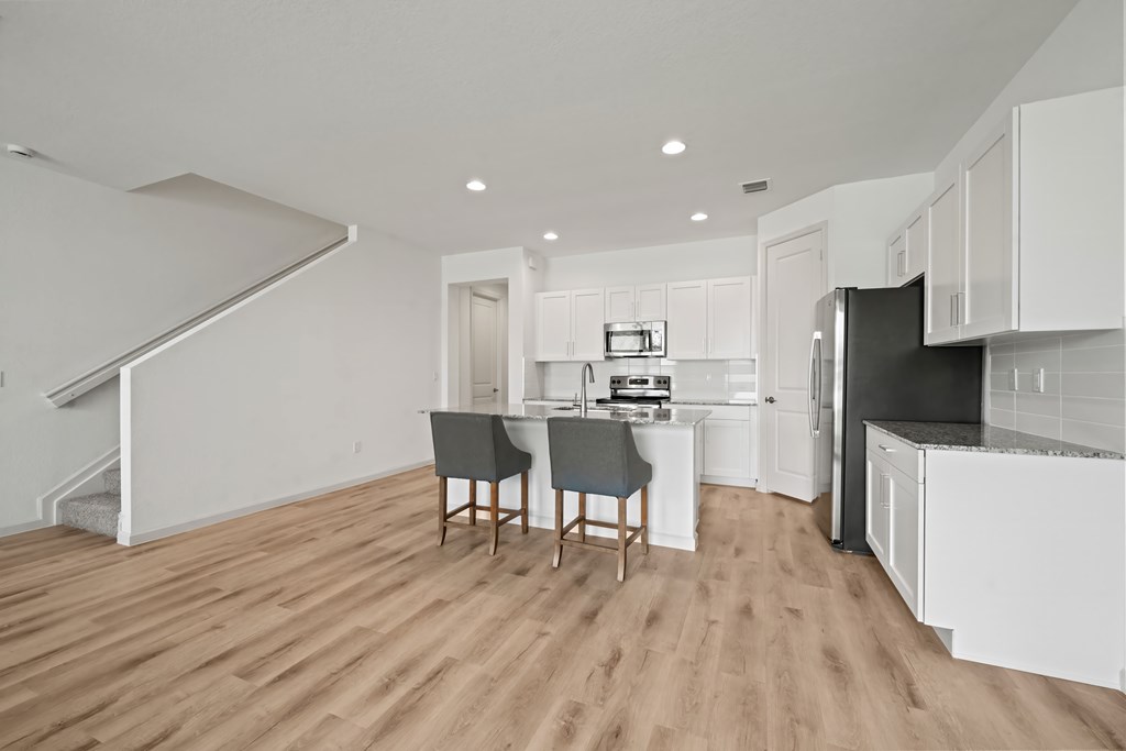 an open kitchen and living room with a dining room table and chairs