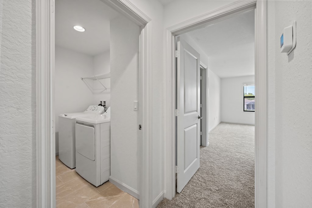 a laundry room with a washer and dryer and a door to a bathroom