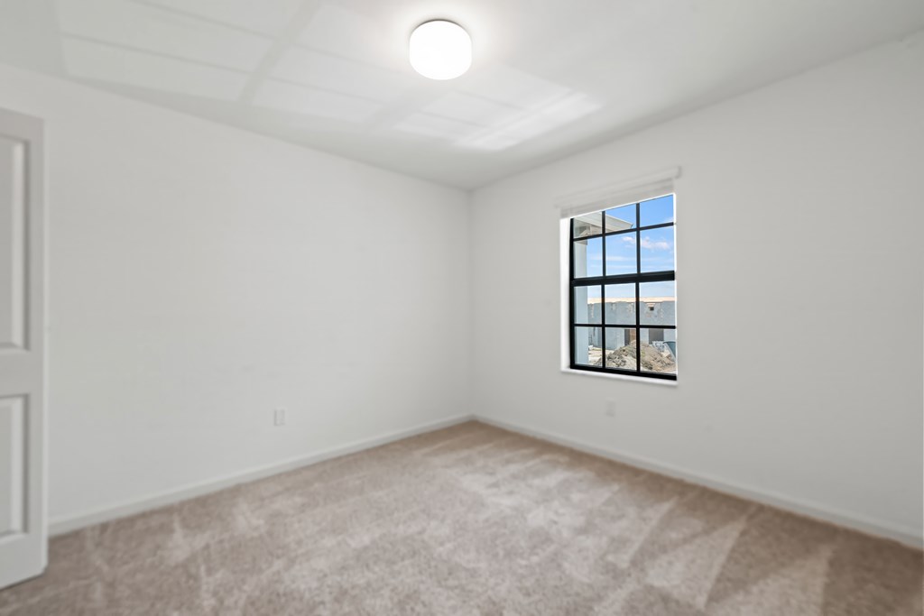 an empty living room with white walls and a window
