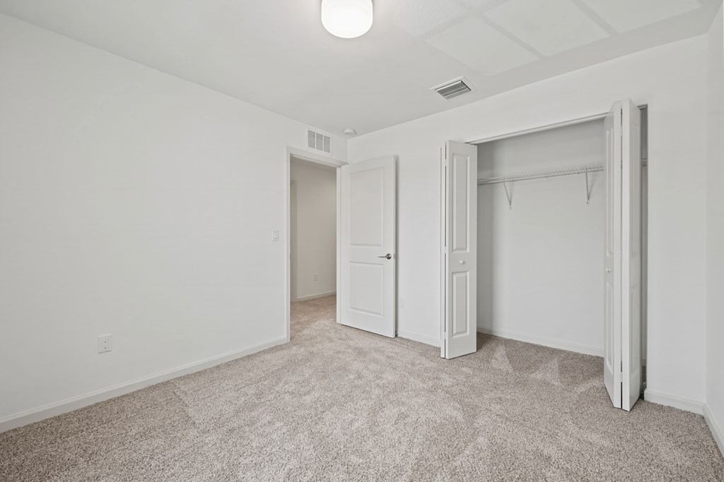 a bedroom with white walls and a closet and white doors