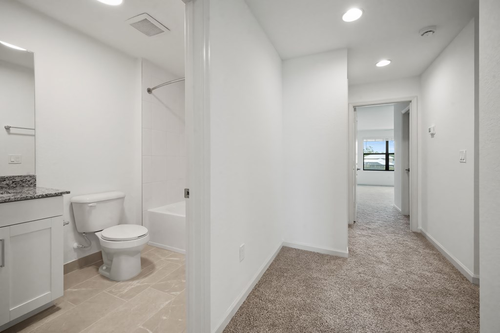 a white bathroom with a toilet and a shower in a house