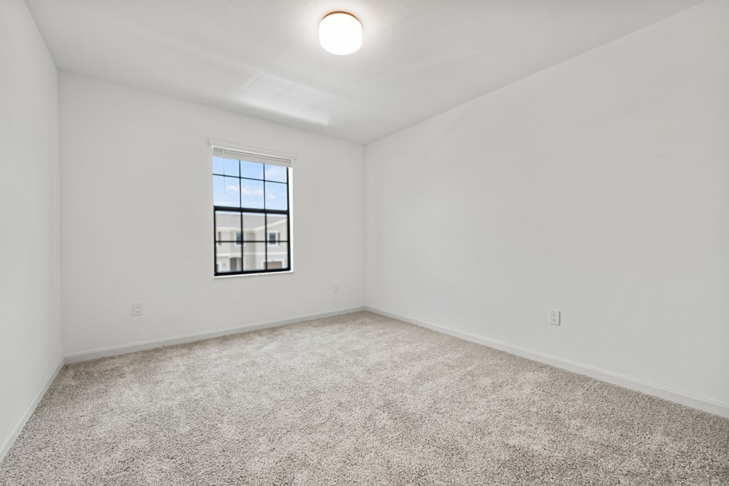 an empty room with carpet and a window