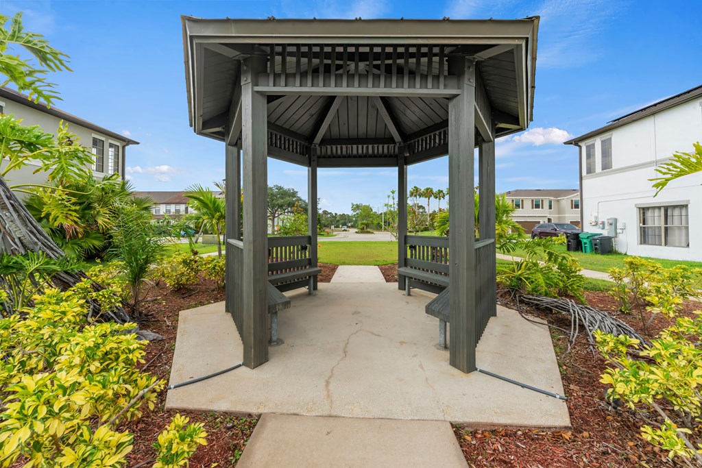 a gazebo with benches in a park