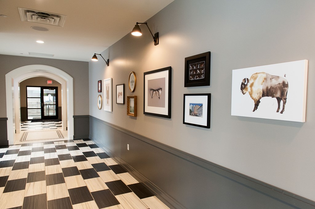 a hallway with pictures on the wall and a checkered floor