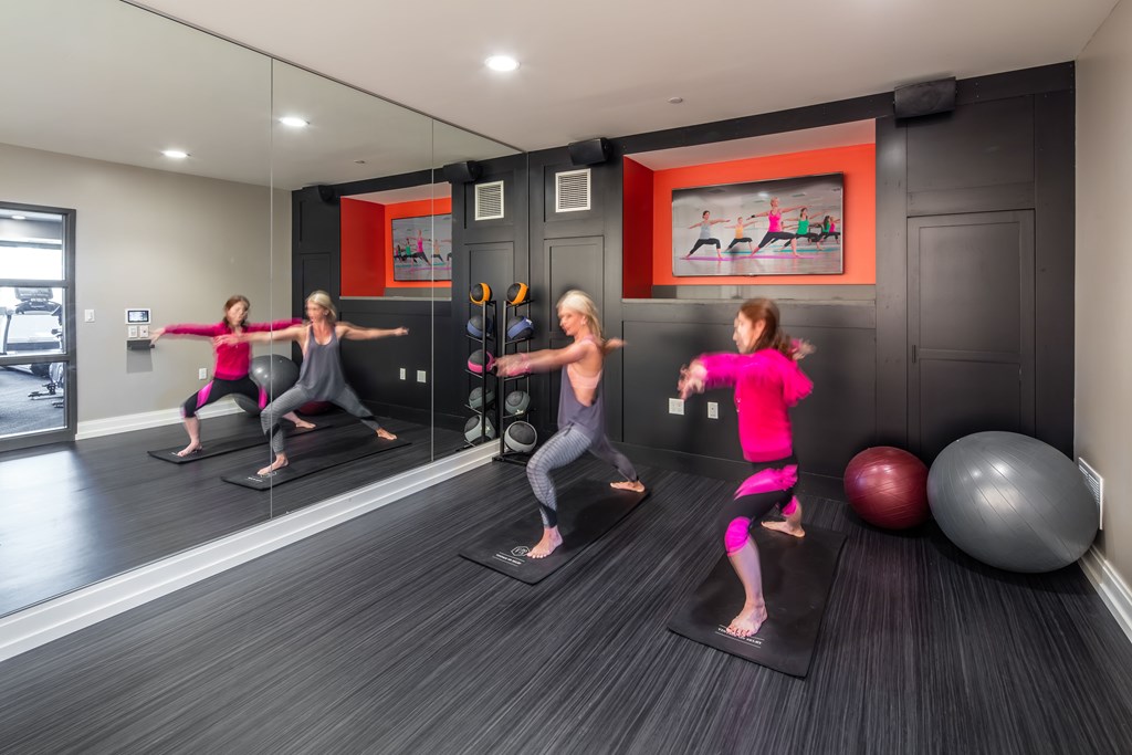 a group of women doing yoga in a yoga room with a yoga ball