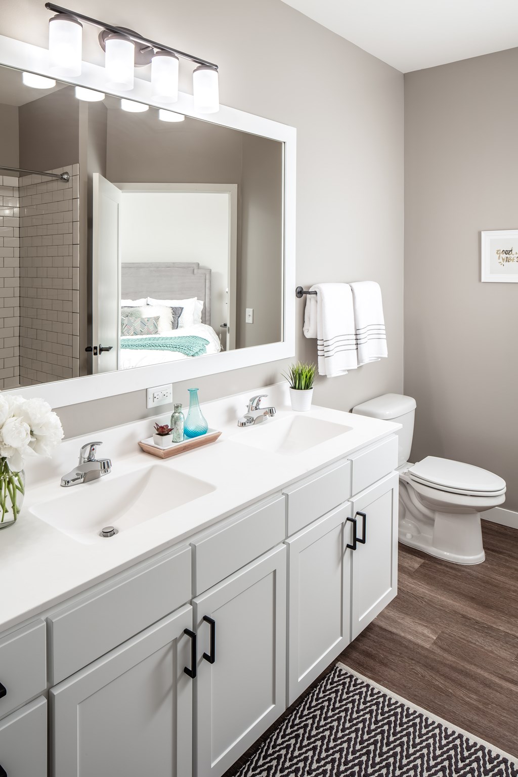 a bathroom with a large mirror and a sink and a toilet