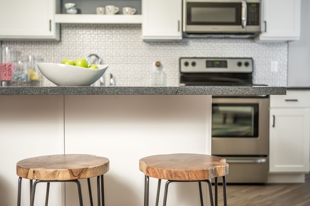 a kitchen with two wooden stools in front of a counter