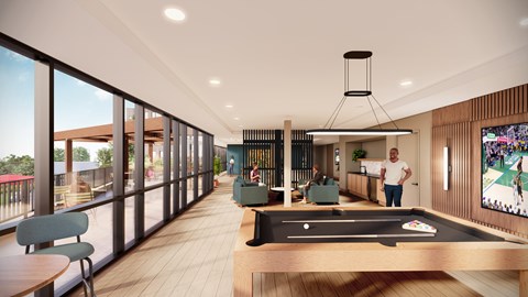 A man is standing in a room with a pool table and a television.