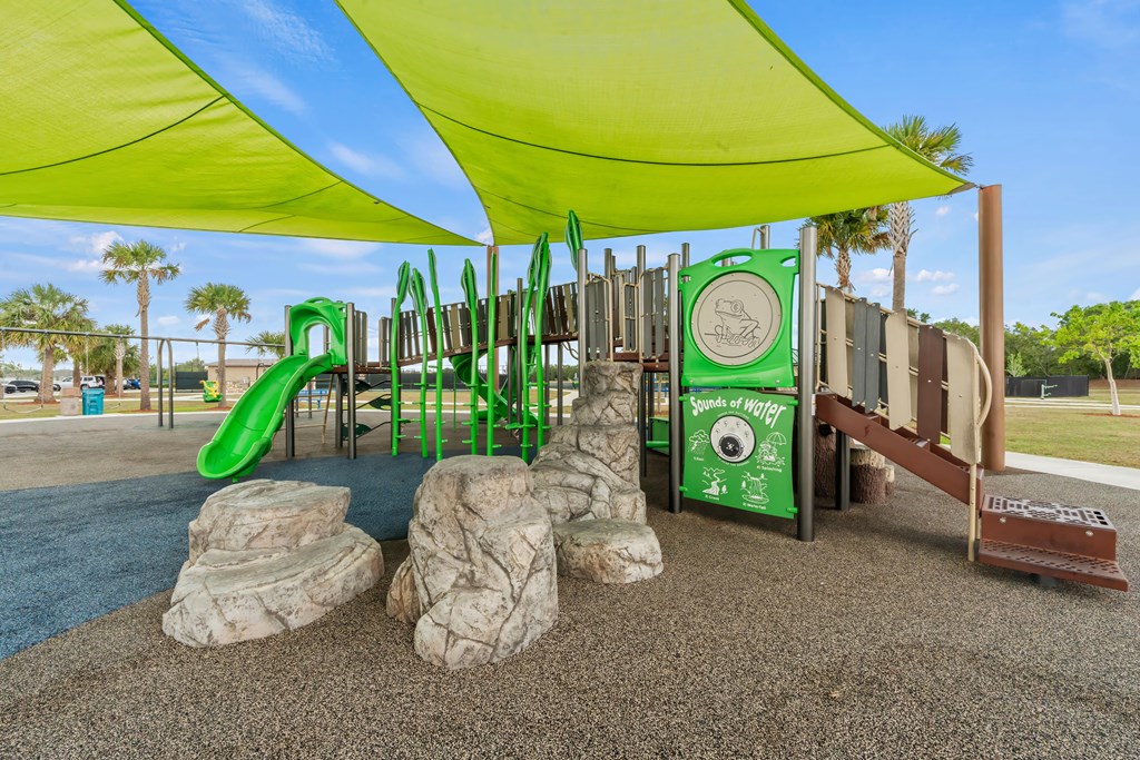 a playground at a park with slides and a tent