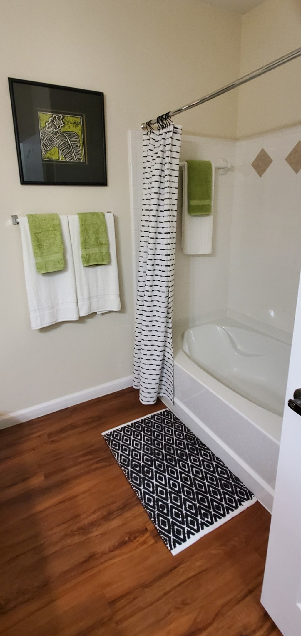 a small bathroom with a shower and a black and white rug