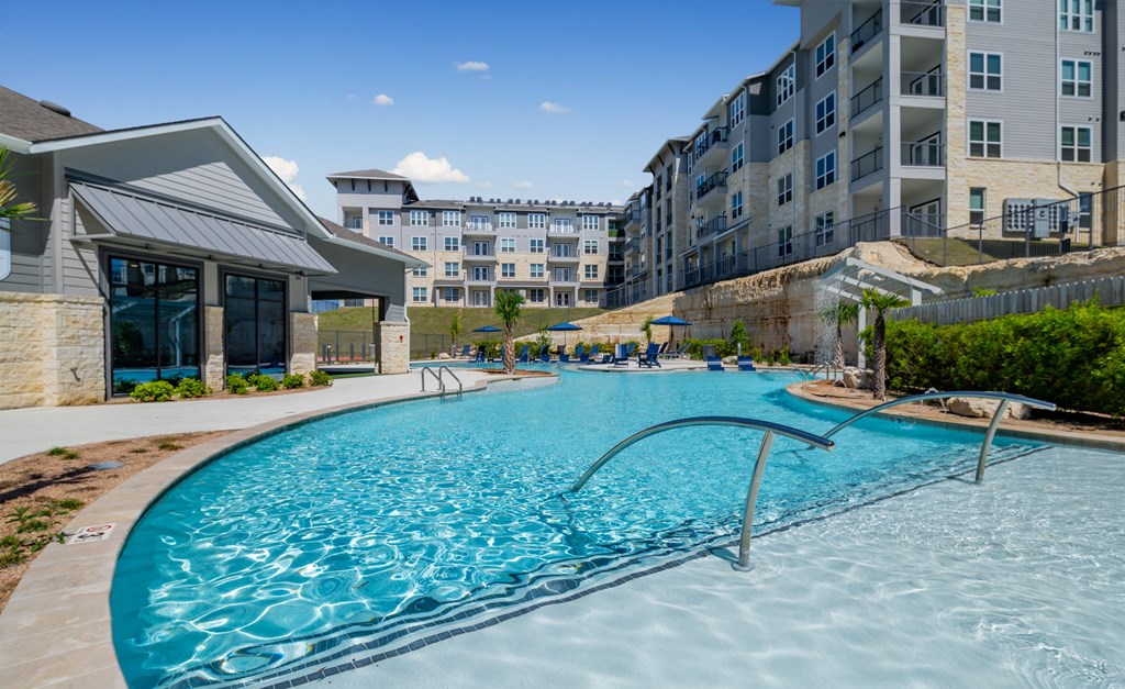 a swimming pool with an apartment building in the background
