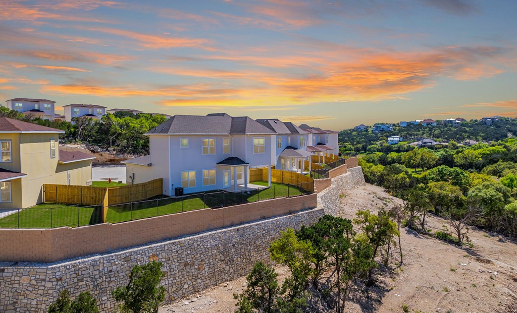 a house on a hill with a sunset behind it