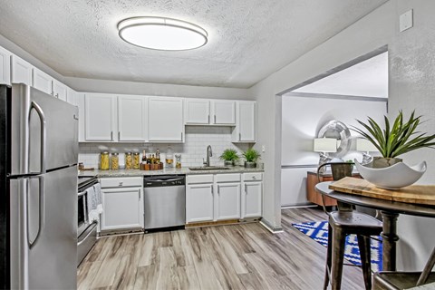 A kitchen with white cabinets and a refrigerator.