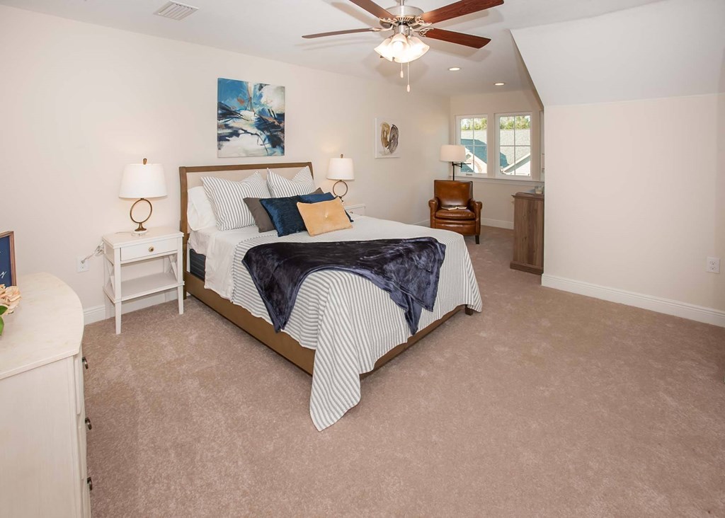 a bedroom with a bed and a ceiling fan