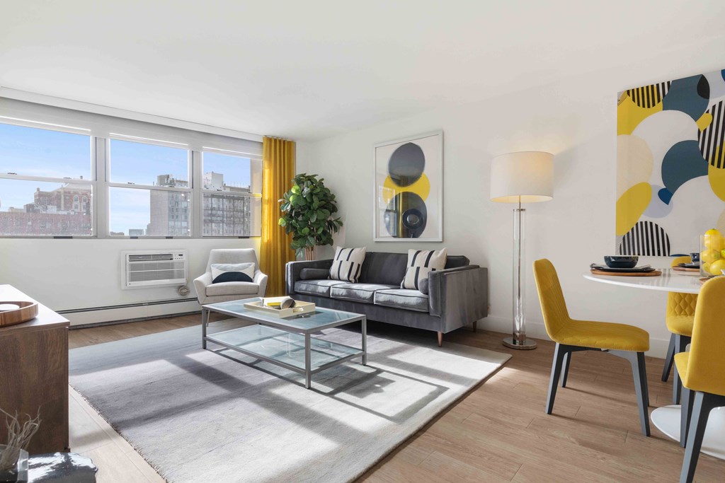 Apartments For Rent Chicago Lakeview - Living Room With Couch, Modern Decor, Coffee Table, Area Rug, Floor Lamp, And AC.