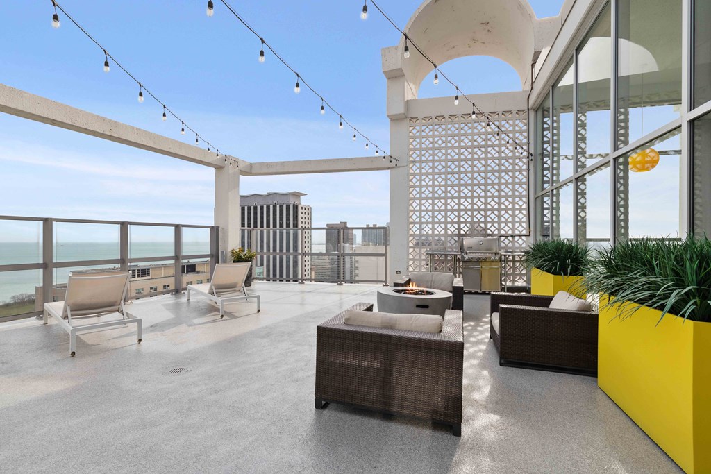 One Bedroom Apartments in Chicago Lakeview IL - Wave Lakeview - Rooftop Sundeck With Firepit, Grilling Station, Lounge Chairs, Cafe Lights, And City Views