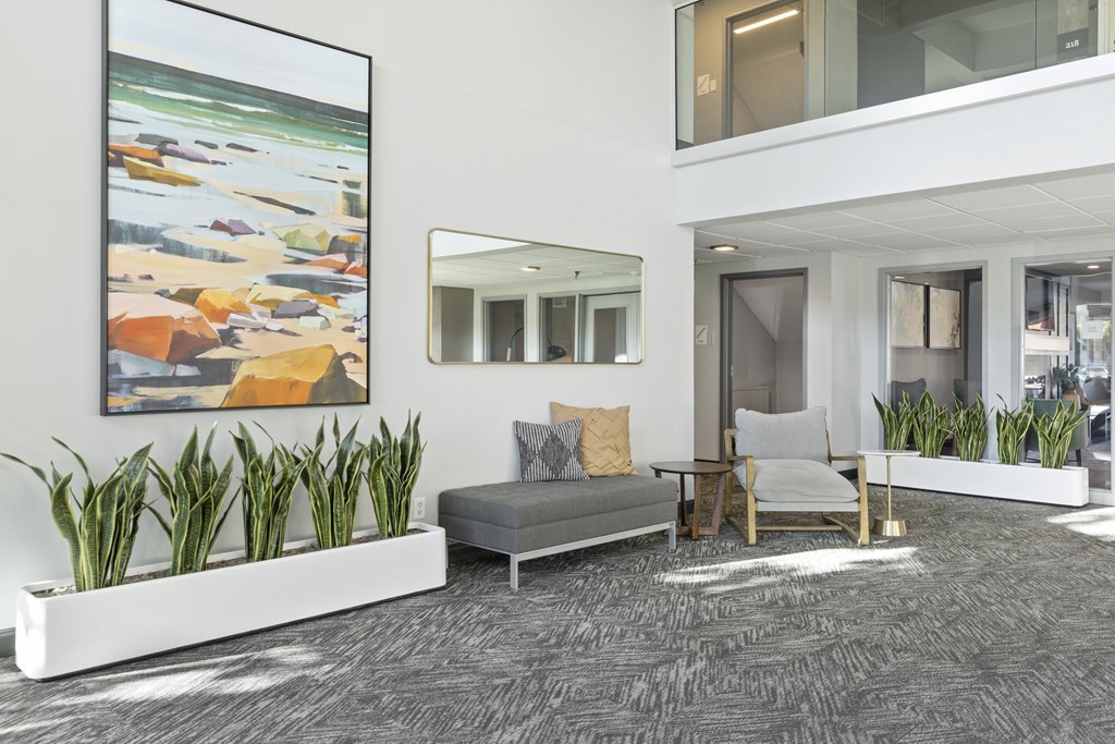 a lobby with a couch and chairs and plants