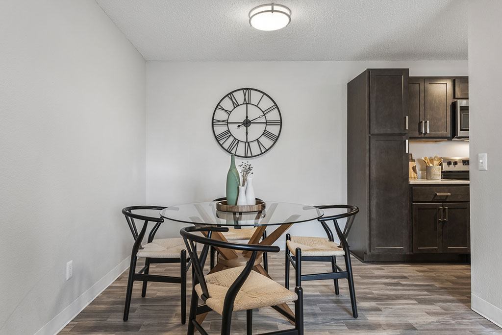a dining room with a table and chairs and a clock on the wall