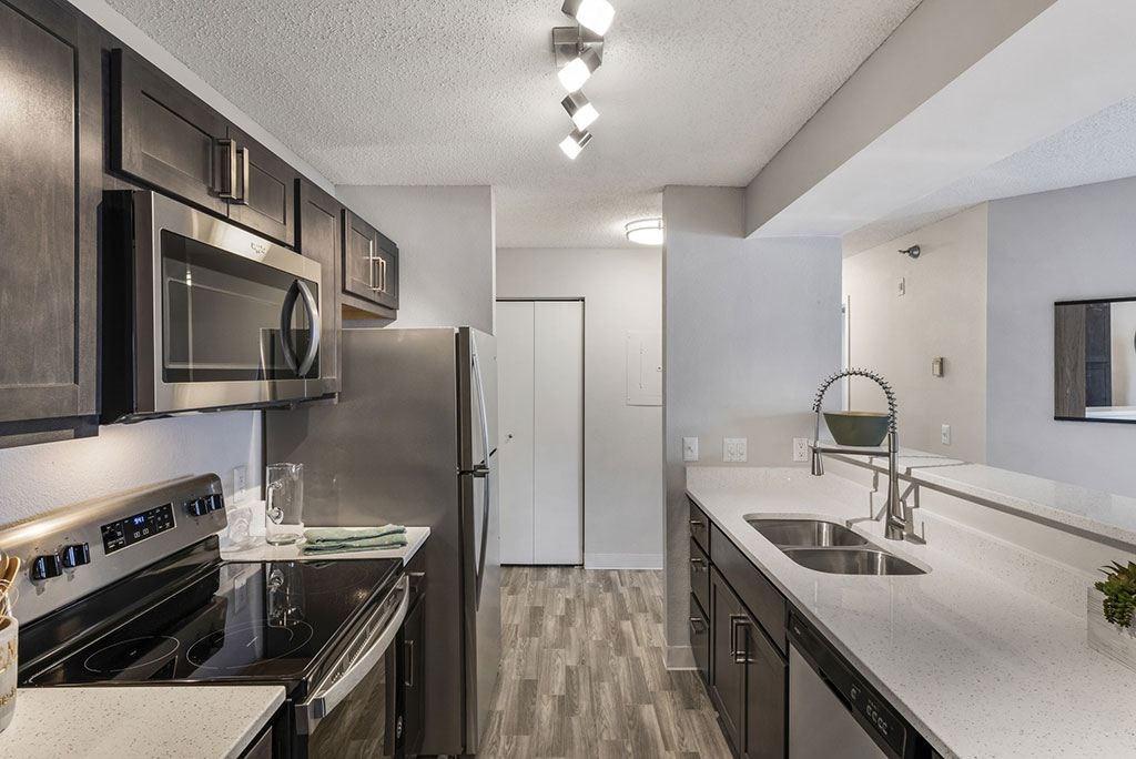 a kitchen with stainless steel appliances and white counter tops