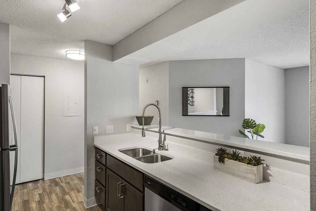an empty kitchen with a sink and a refrigerator
