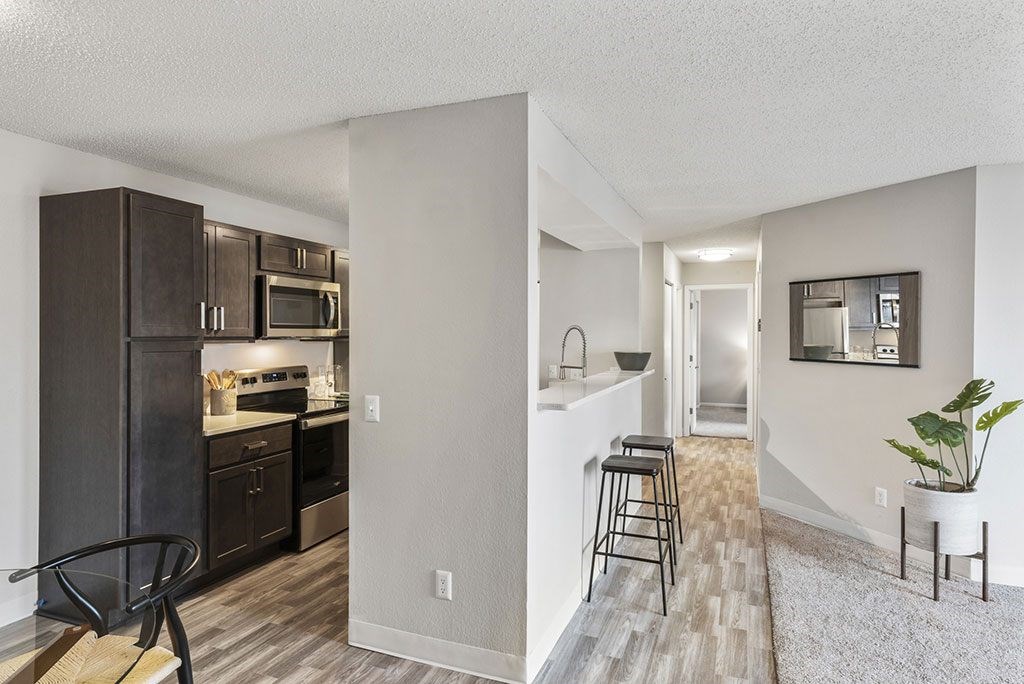 an open kitchen and living room with a bar and stools