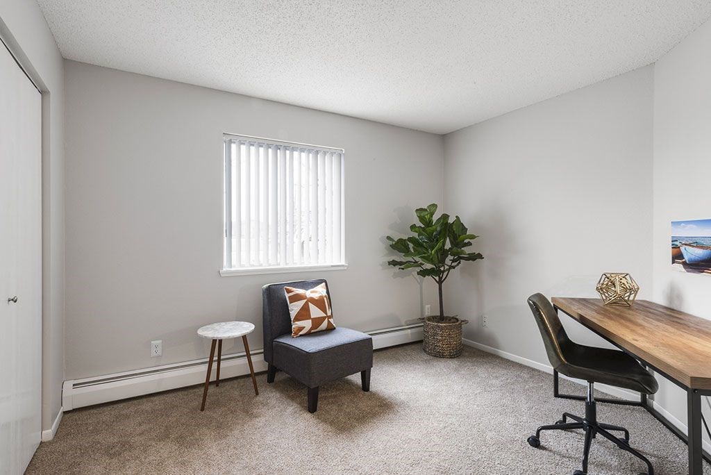 an office with a chair and a desk and a window