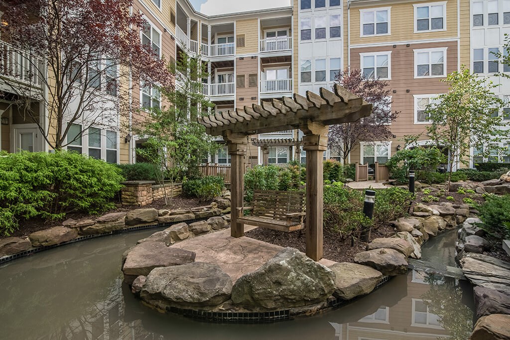 a pond with a wooden structure in front of a building