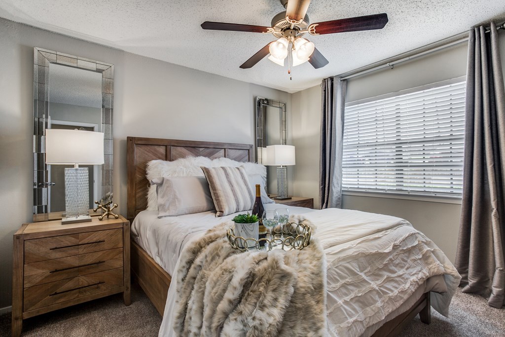 create a cozy bedroom with a large bed and a ceiling fan