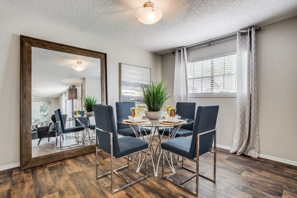a dining room with a table and chairs, hardwood floors