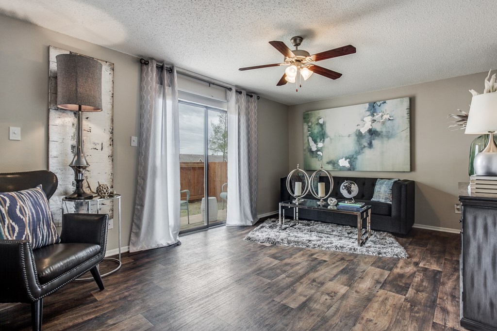 a living room with a ceiling fan and a sliding glass door
