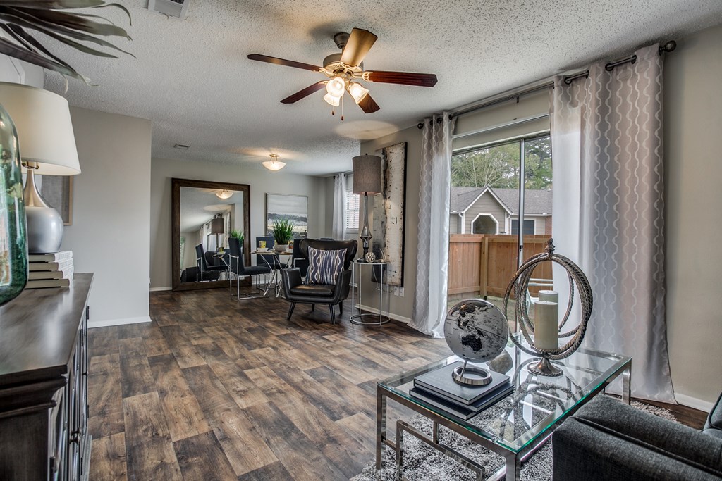 a living room with a large window and a ceiling fan