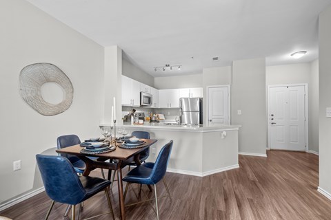 A kitchen with a dining table and chairs.