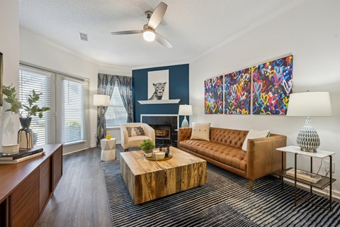 A living room with a brown couch, a coffee table, and a painting on the wall.