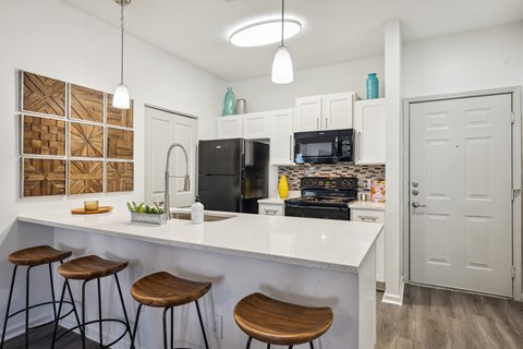 A kitchen with white cabinets and a white counter top.