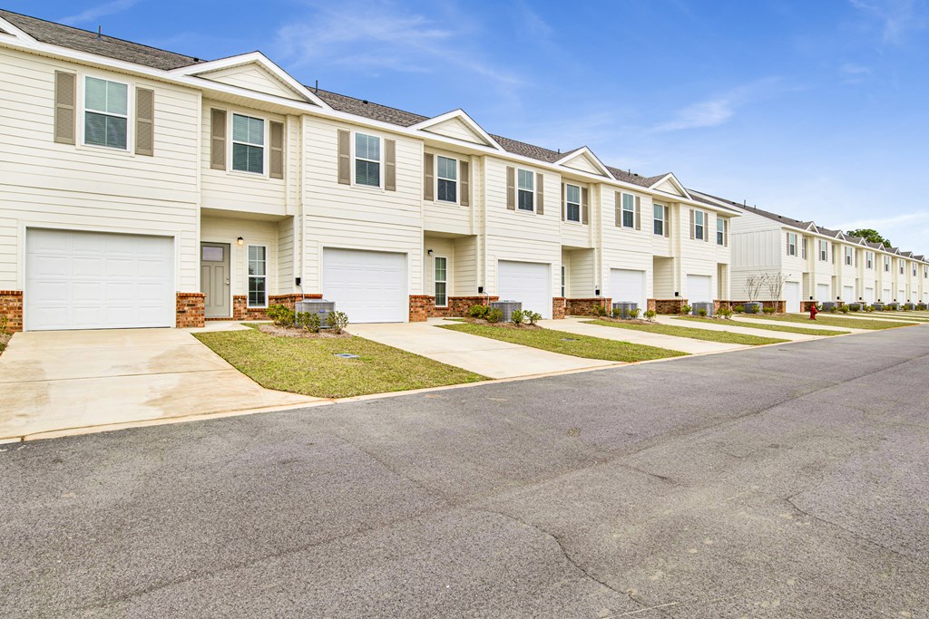 a row of white houses on the side of a street