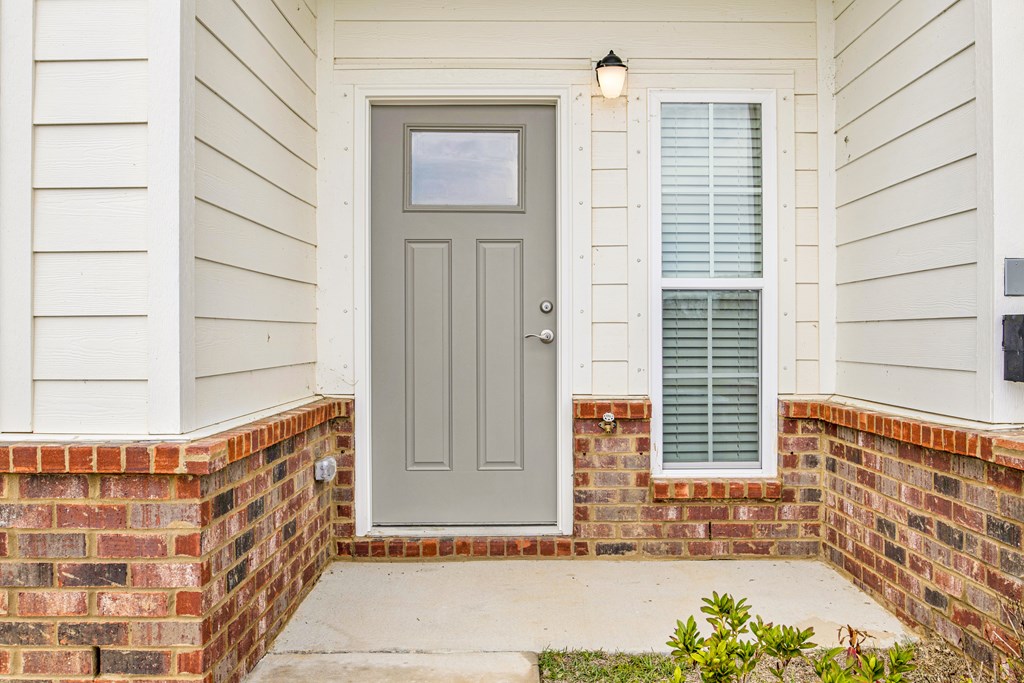 the front door of a home with a brick porch and