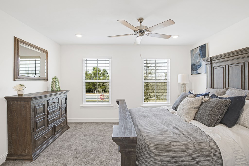 a bedroom with a large bed and a ceiling fan