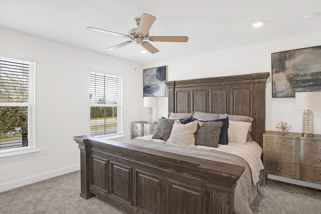 a bedroom with a large bed and a ceiling fan