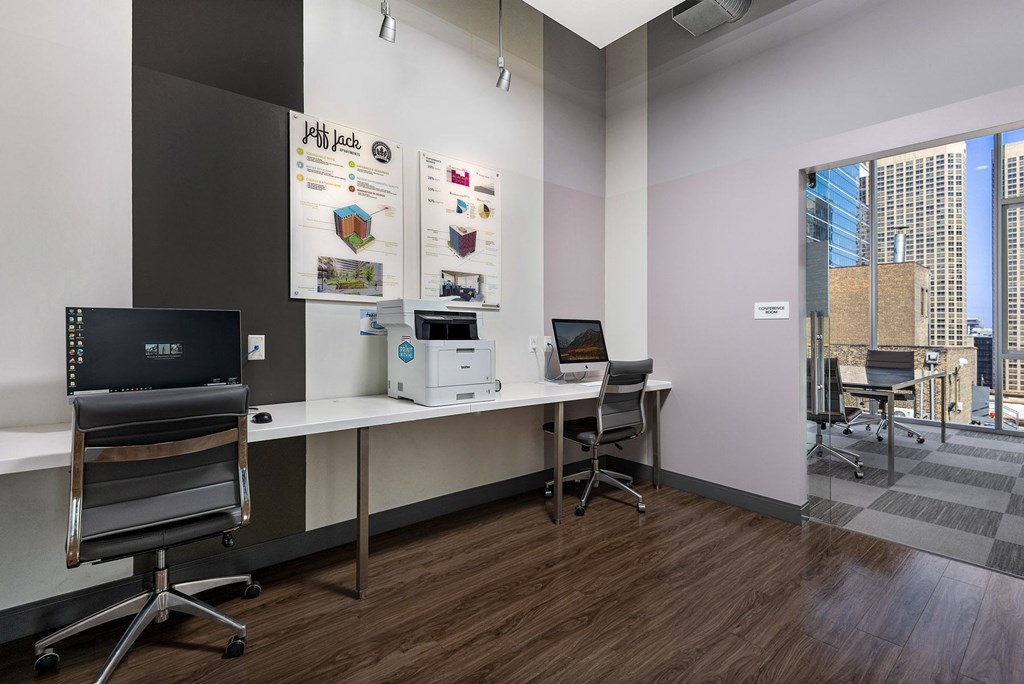 an office with a desk with a computer and a window