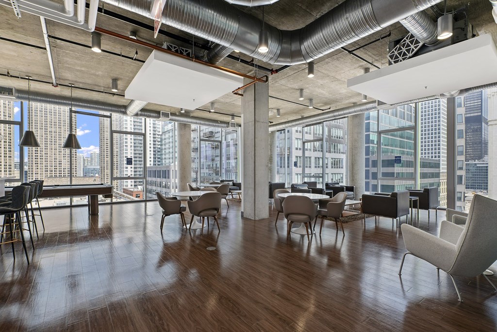 a large room with tables and chairs and a view of a city