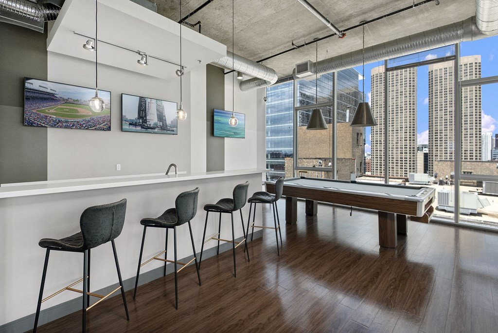 a game room with a pool table and a view of the city
