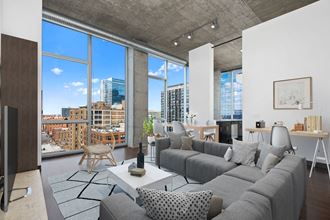 a living room with a gray couch and a view of the city
