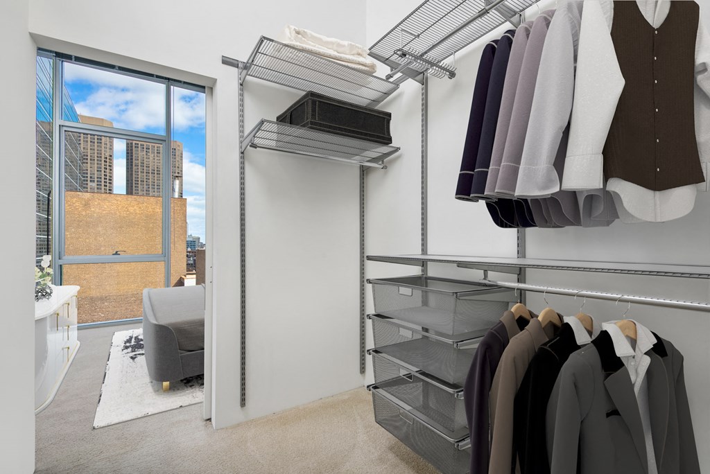 a closet with a sliding glass door and a rack of clothes