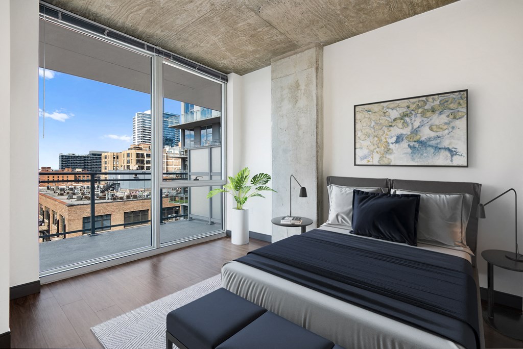 a bedroom with a bed and a large window with a city view