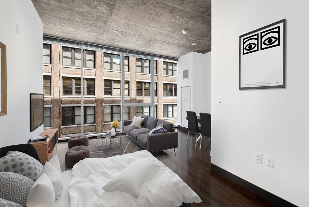 a living room with a couch and a bed and a large window